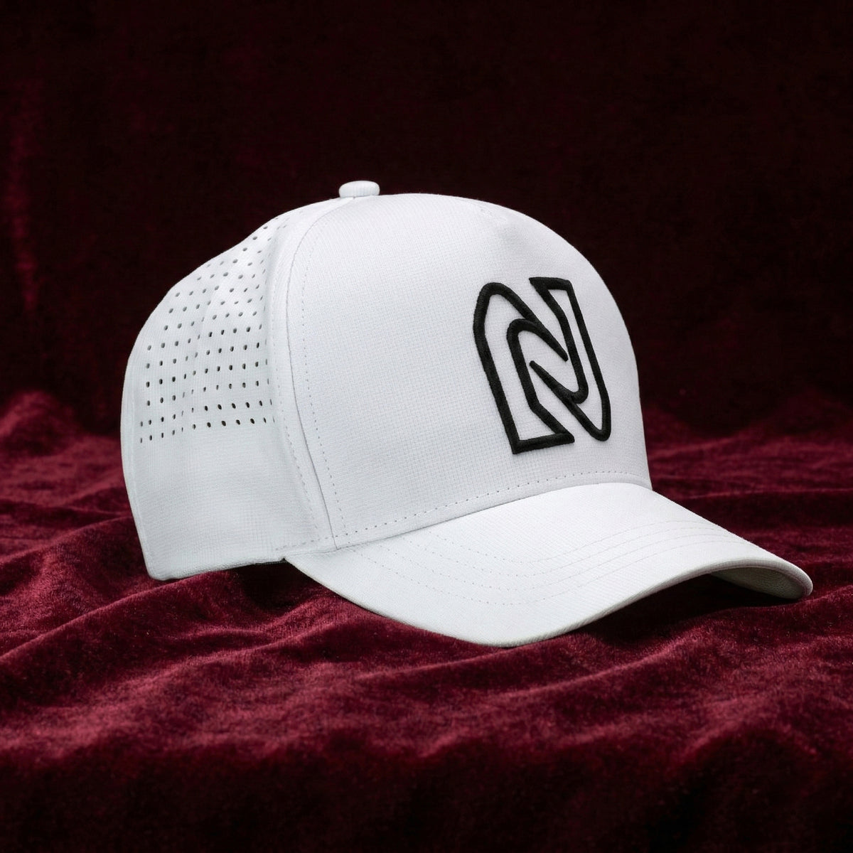 White cap with a black logo on a red fabric background