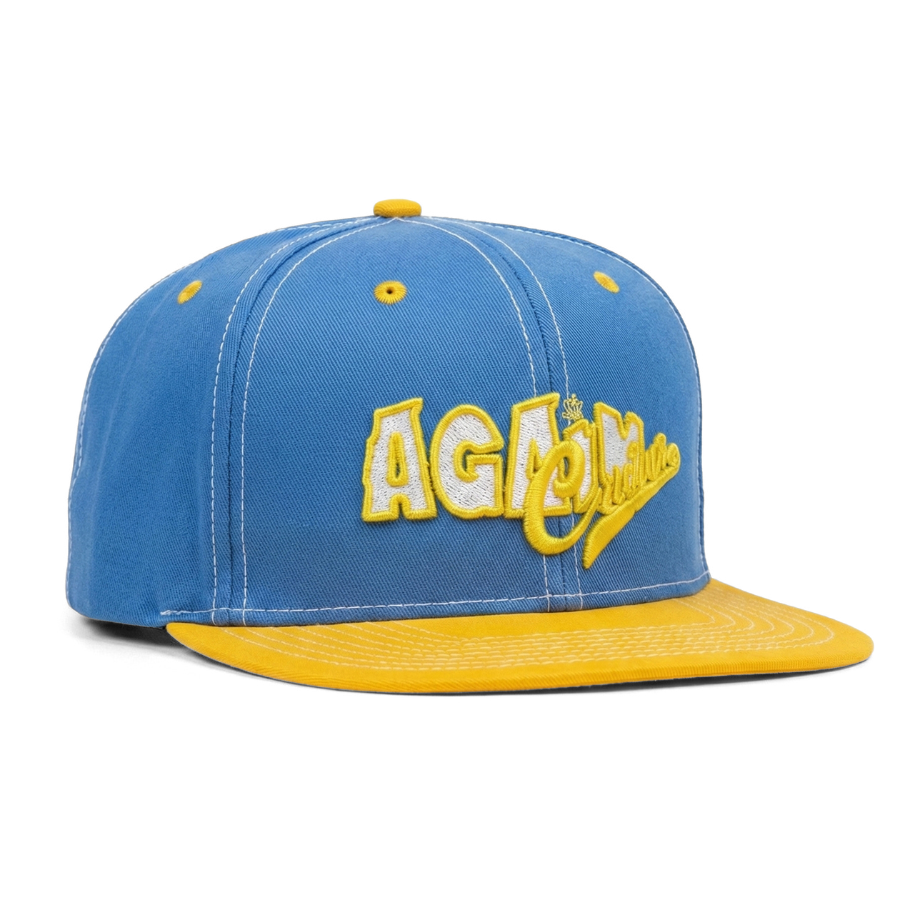 Blue and yellow cap with 'AGATHA' branding on a white background