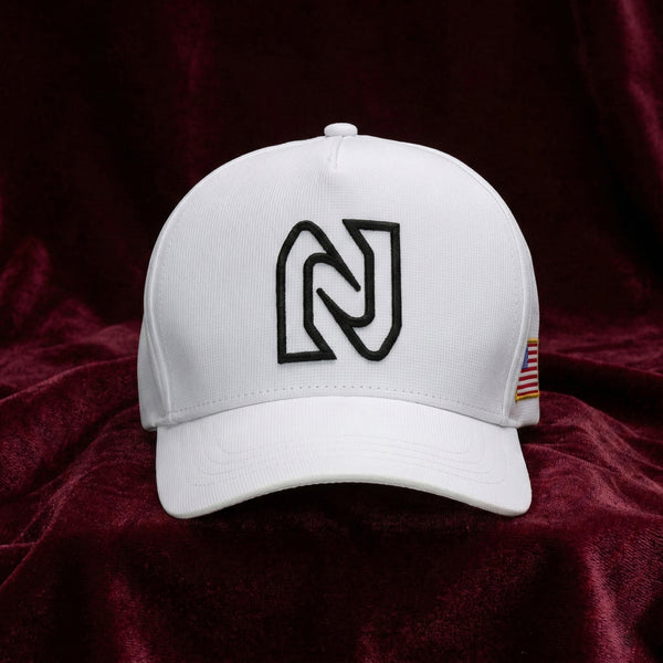 White cap with a black logo on a dark red fabric background