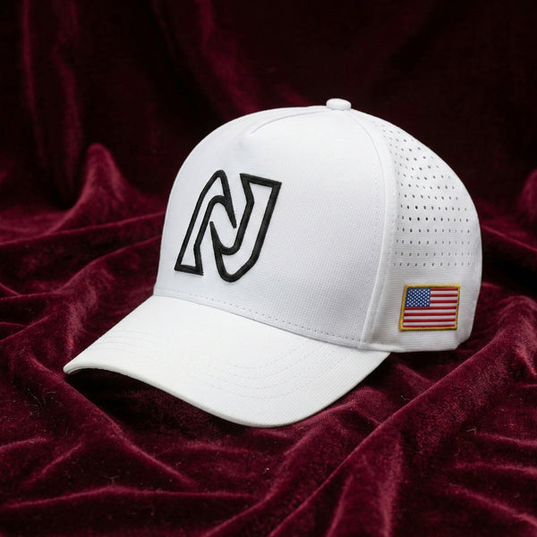 White baseball cap with black logo and American flag patch on a red velvet background
