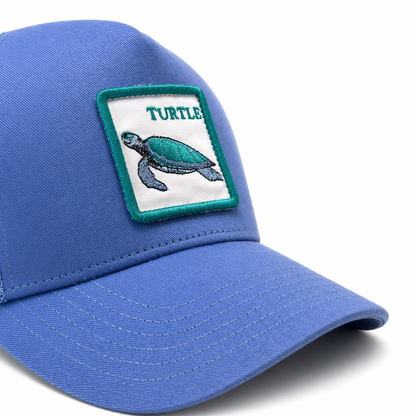 Blue cap with a turtle patch on a white background