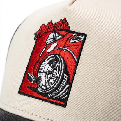 Beige cap with a red and black embroidered patch featuring a car and 'Authentic' text.